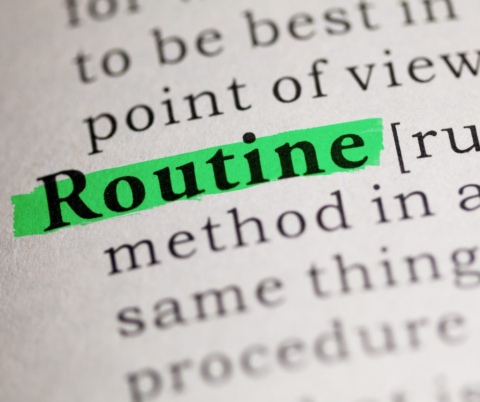 A close-up of a book page with the word "Routine" highlighted in bright green, with the word in bold black text. The surrounding text is blurry and partially visible.