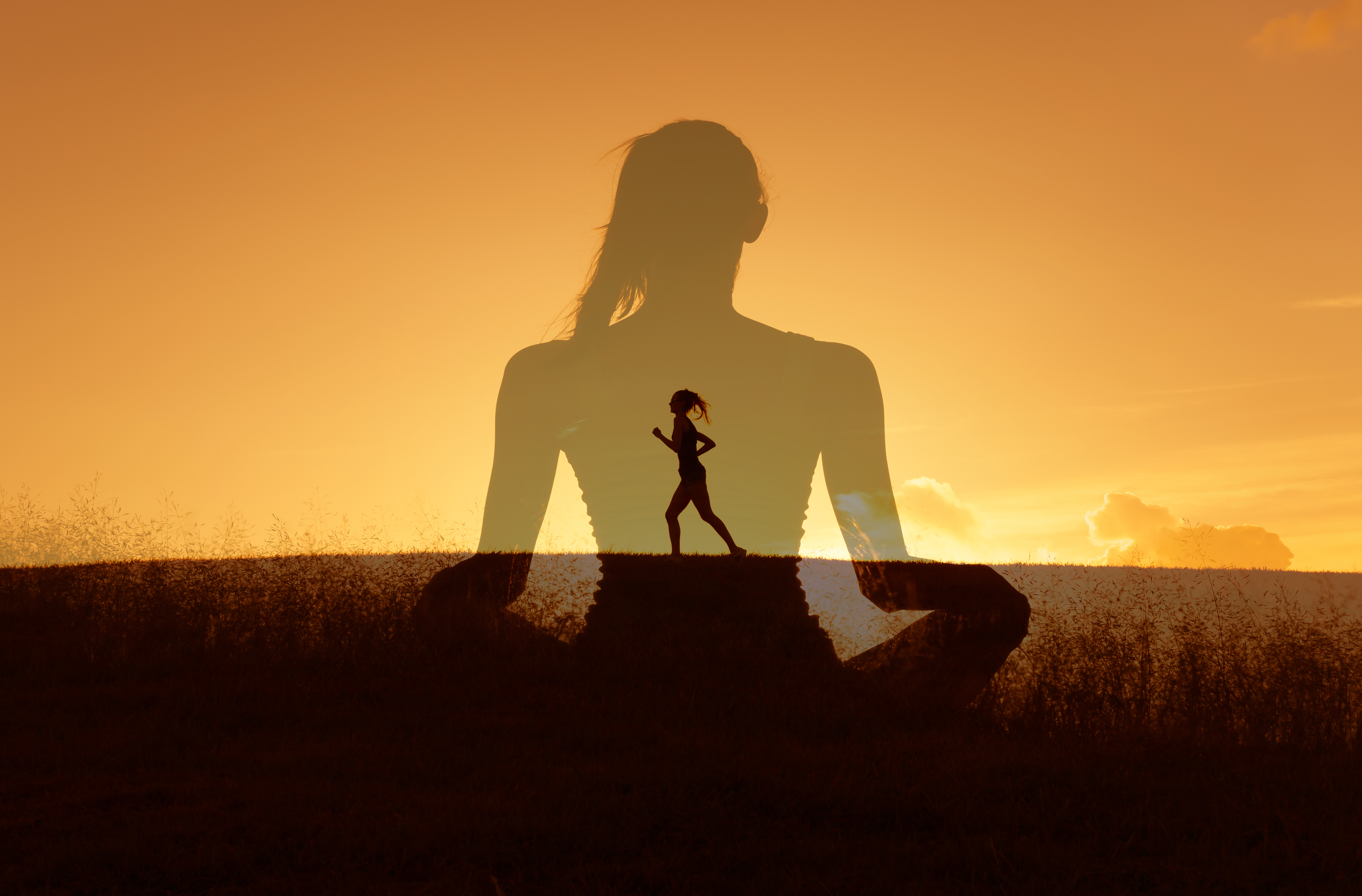 Double-exposure image showing a woman running across a hill at sunset within the larger silhouette of a woman meditating, symbolizing inner strength and mind–body connection.